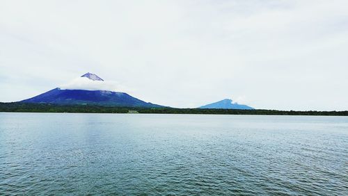 Scenic view of lake by mountain against sky
