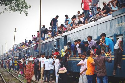 Low angle view of crowd on train against sky