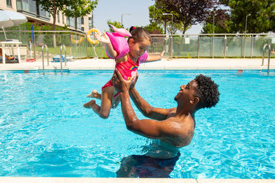 Father and daughter having fun in pool