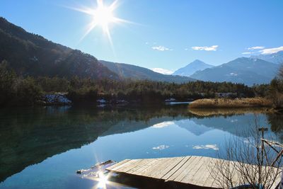 Scenic view of lake and mountains against sky on sunny day