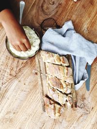 High angle view of man preparing bread on table