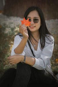 Portrait of young woman holding flower