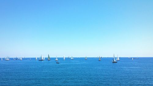 Boats in sea against clear sky