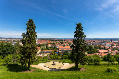 Trees and townscape against blue sky