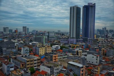 Aerial view of buildings in city against sky