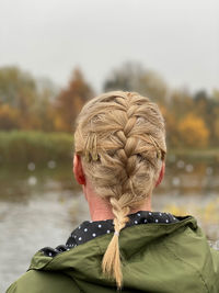 Rear view of woman looking at lake against sky