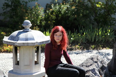 Thoughtful young woman sitting at park