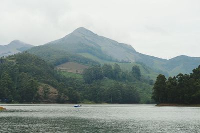 Scenic view of river and mountains against sky