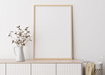 Empty vertical picture frame on white wall in modern living room. mock up interior 