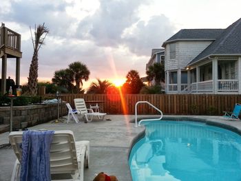 Swimming pool against sky at sunset