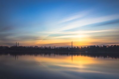 Scenic view of river against sky at sunset