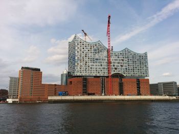 Buildings in city against cloudy sky