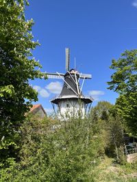 Dutch windmill with trees under a blue sky