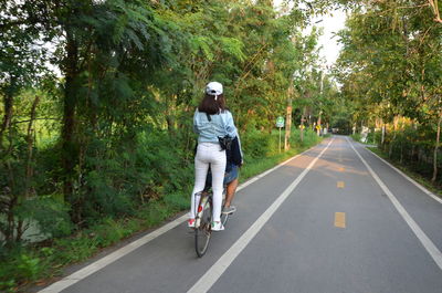 Full length of man riding bicycle on road