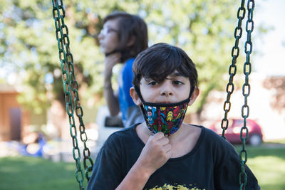 Children playing in playground wearing face mask