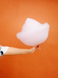 Fluffy cotton candy against an orange wall