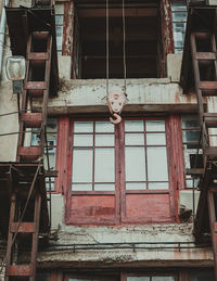 Low angle view of hook hanging against building at construction site