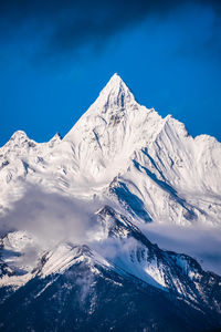 Scenic view of snowcapped mountains against blue sky