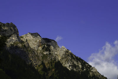 Low angle view of rocks against blue sky