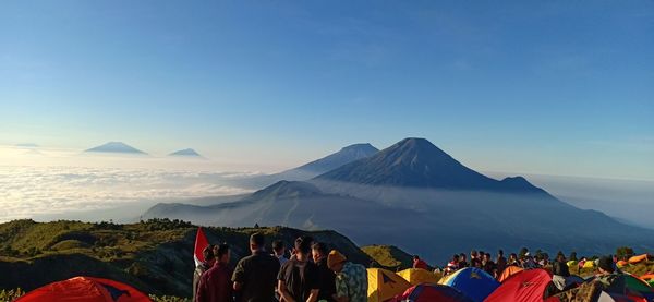 Group of people on mountain against sky