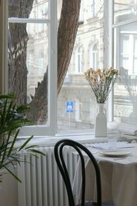 Flower vase on table by window at home