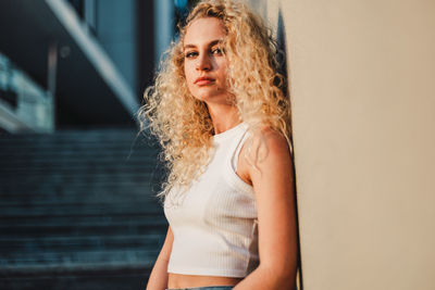 Portrait of woman standing against wall