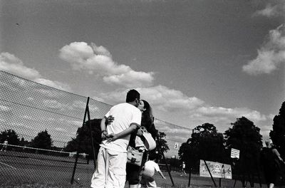 Low angle view of people against cloudy sky