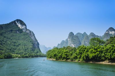 Scenic view of river and mountains against clear sky