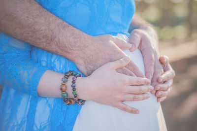 Close-up of hands against blue sky