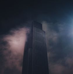 Low angle view of skyscrapers against cloudy sky