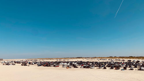 People on beach against clear blue sky