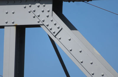 Low angle view of metal against clear blue sky