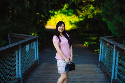 Portrait of woman standing on railing