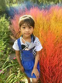 Portrait of smiling girl standing against plants