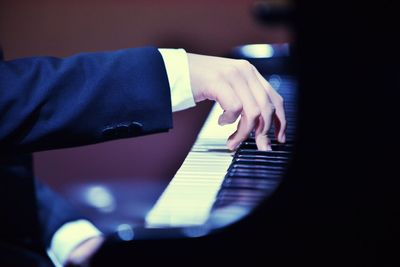 Cropped hands of man playing piano