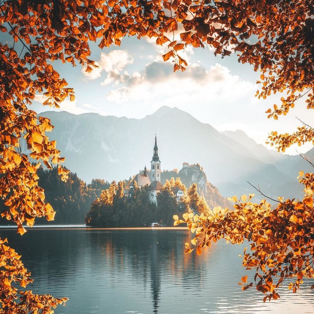 tree, sky, plant, autumn, nature, architecture, water, built structure, orange color, no people, beauty in nature, change, travel destinations, religion, lake, spirituality, building exterior, place of worship, belief, outdoors