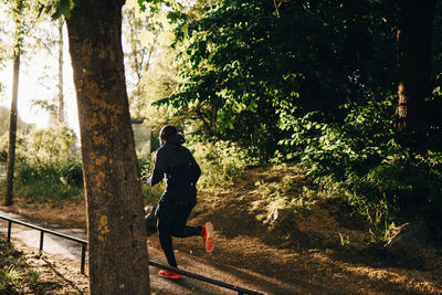 Full length of male athlete running on footpath in park