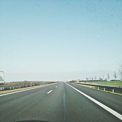 Empty road along trees