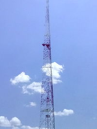 Low angle view of electricity pylon against blue sky