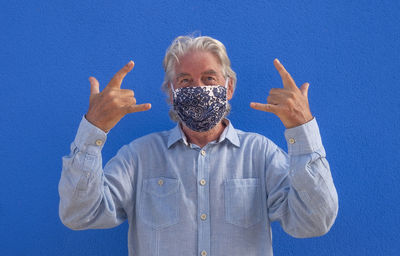 Portrait of man standing against blue background