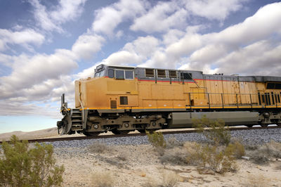 Diesel locomotive cruising through the mojave desert just north of barstow, california