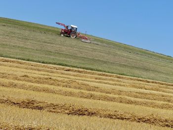 Tractor on agricultural field against sky