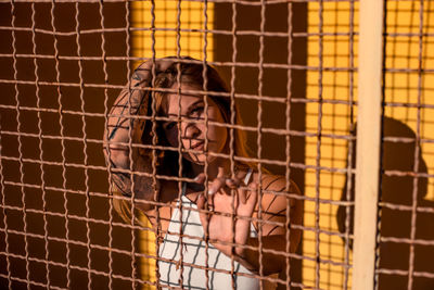 Portrait of woman in metal cage