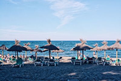 People on beach against clear blue sky