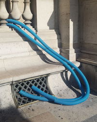 Blue plastic pipes by concrete railing