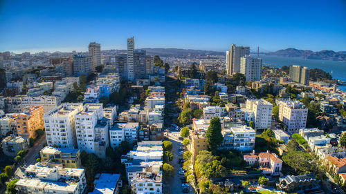 High angle view of buildings in city against blue sky