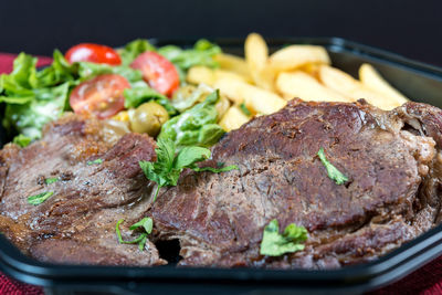 Close-up of roasted beef in tray at table