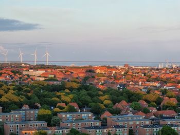 High angle view of townscape by sea against sky