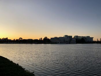 Scenic view of river by buildings against clear sky