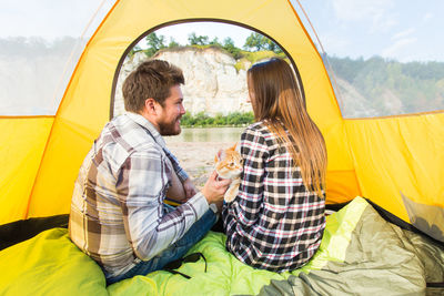 Young couple sitting in tent